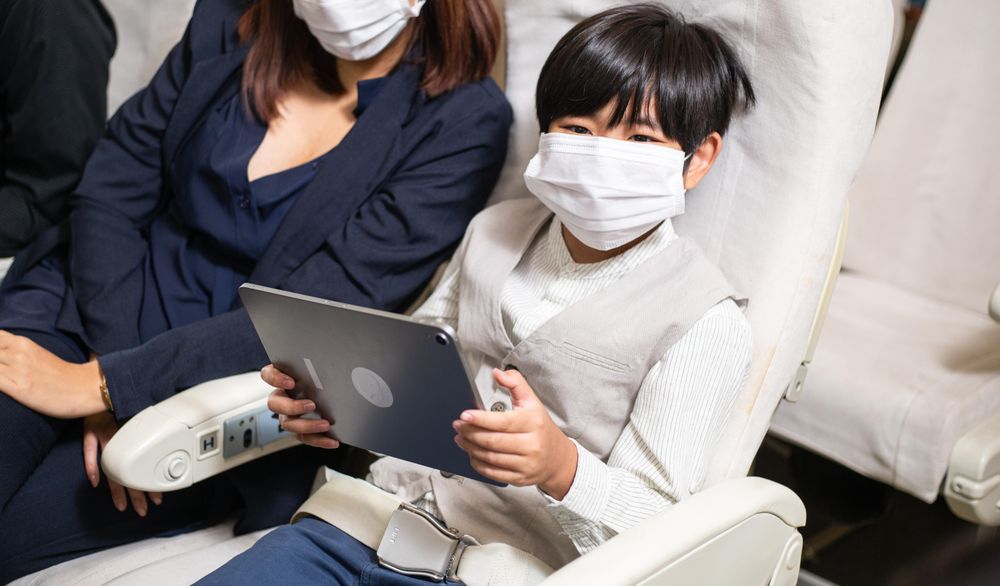 Young boy using tablet on flight