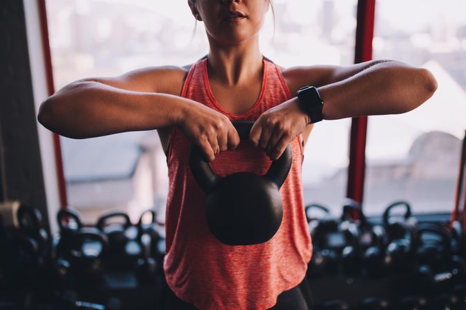 Woman holding a kettlebell to her chest at the gym