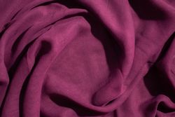 Soft purple fabric wavy spiral crumpled background abstract with copy space in the center