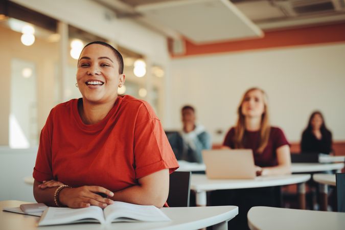 College student smiling in class with students behind her