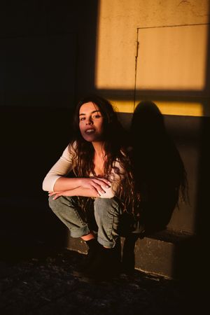 Smiling woman sitting in spot of light