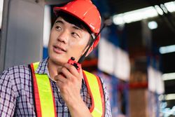 Man in PPE gear talking on walkie talkie