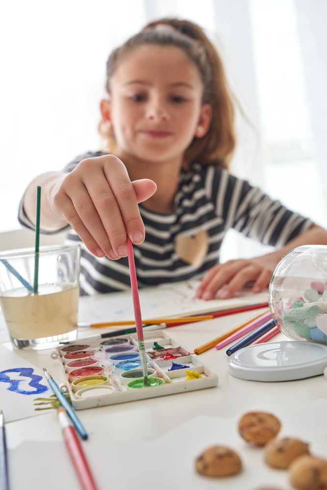 Girl with paints at table