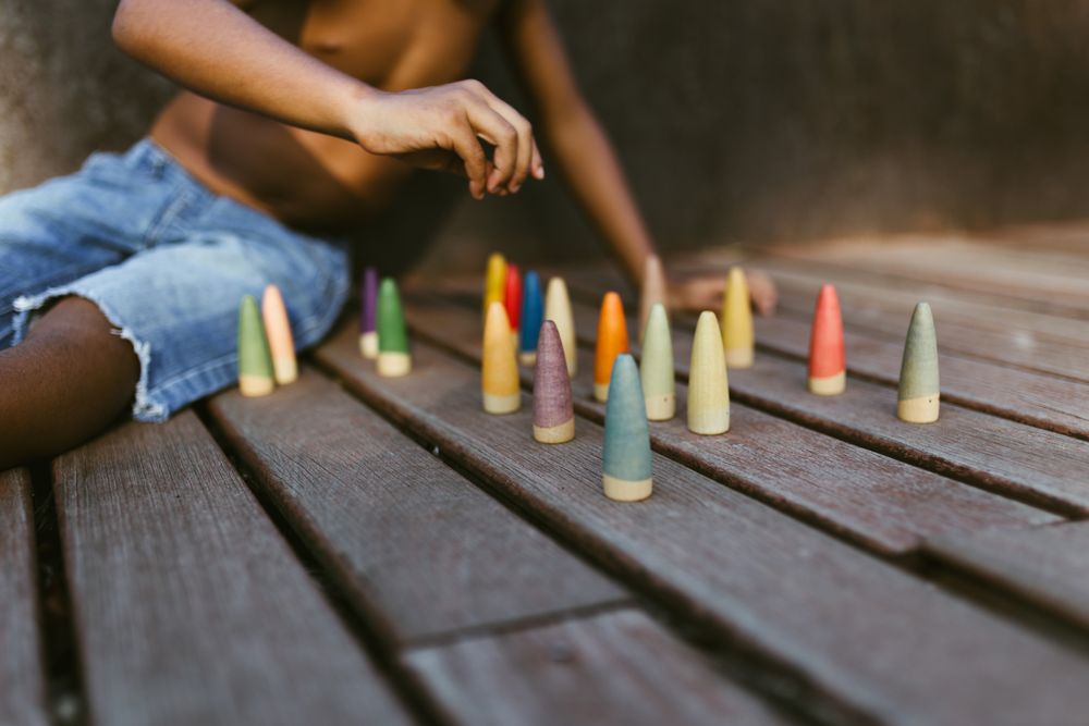 Crop Black kid playing with cones