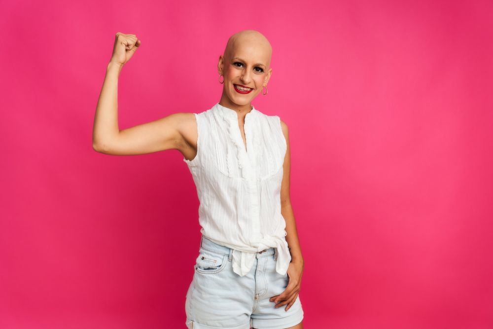 portrait of a woman suffering from breast cancer, with an optimistic gesture of strength and hope