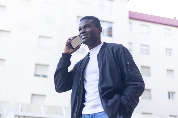 Black man walking outside talking on his phone