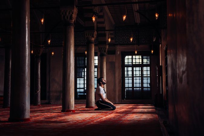 Man kneeling inside Mosque praying