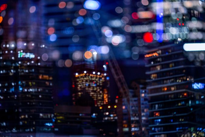 Blurry photo of city with high rise buildings during night time