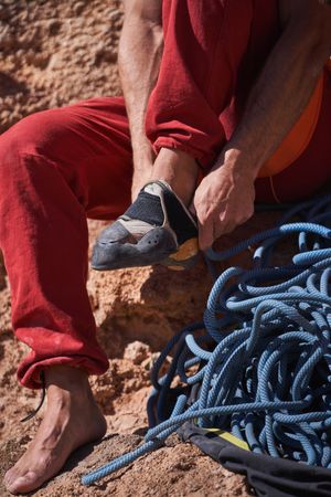 Unrecognizable person putting on climbing shoes