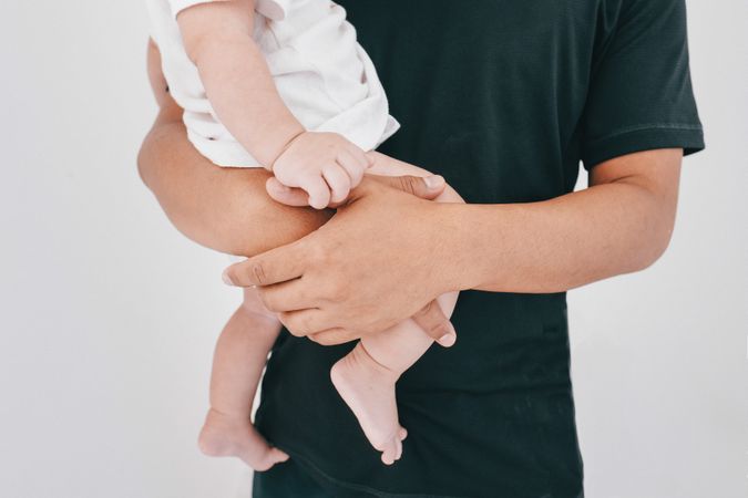 Anonymous man holding a baby