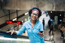 Woman smiling on escalator exiting the subway