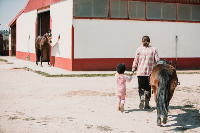 Woman with girl and pony on ranch