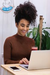 Black woman working on laptop in cafe
