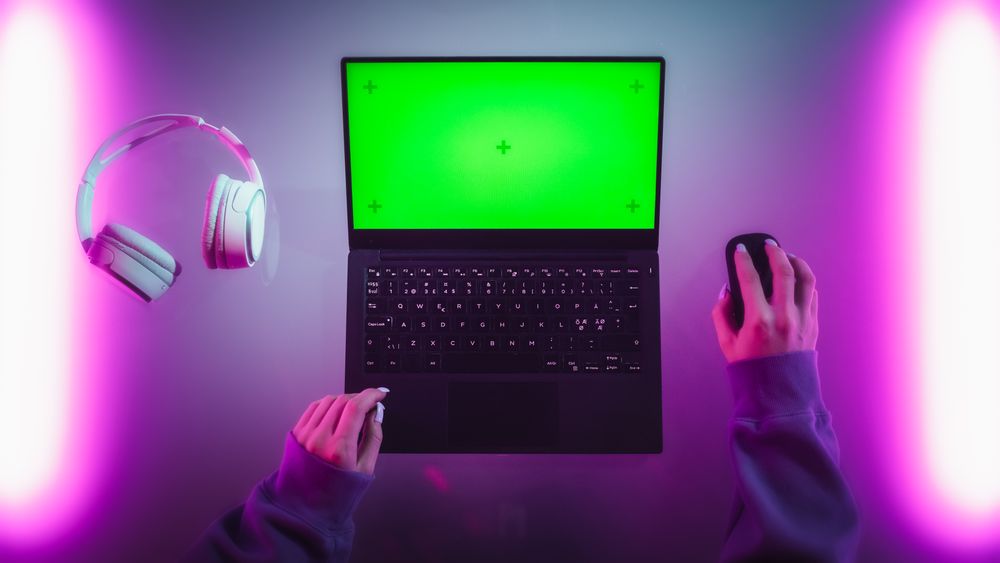 Top Down Shot of a Female Software Developer Working on a Laptop in a Stylish Room with Neon Lights. Computer with Green Screen Chroma Key Template for Digital Marketing Services, Apps, Software