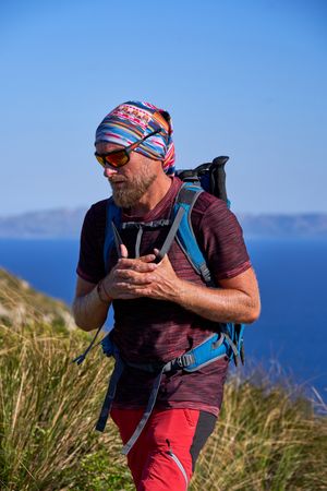 Male hiker with backpack in mountains on sunny day