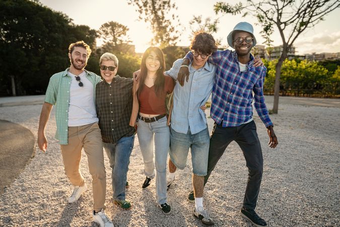 Happy diverse group of young friends walking together outdoors and smiling.