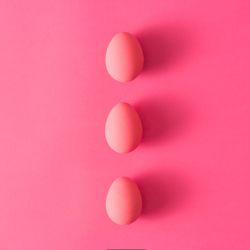 Row of three pink Easter eggs on pink background