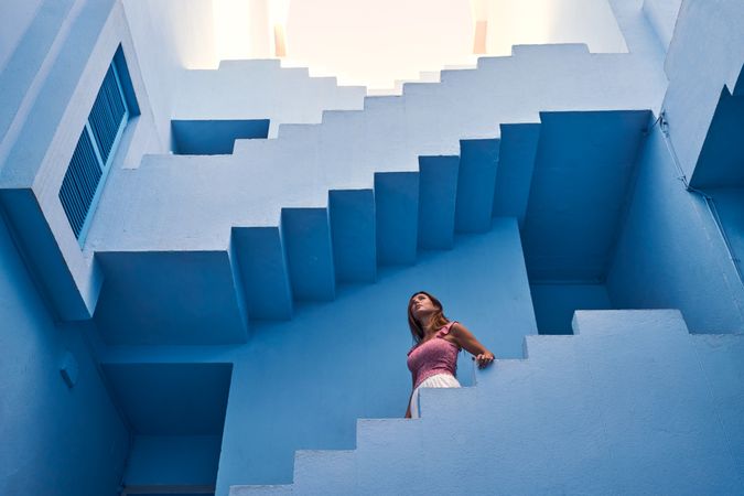 Woman walking downstairs on modern blue building