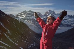 Child shouting against snowy mountain range