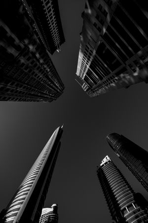 Low angle of skyscrapers in Dubai in grayscale