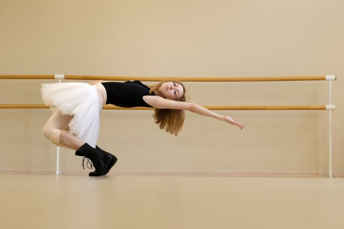 Ballerina in shoes and tutu, leaning backward gracefully