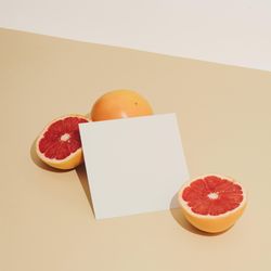 Grapefruit halved with paper card on beige background