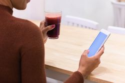 Anonymous Black woman using mobile phone in cafe