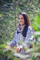Smiling Hispanic woman with backpack in nature