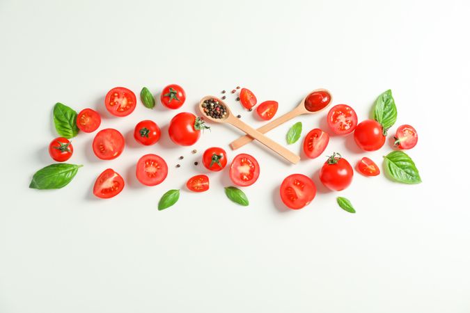 Flat lay composition with fresh tomatoes, pepper, basil and wooden spoons on blank background, space for text. Ripe vegetables