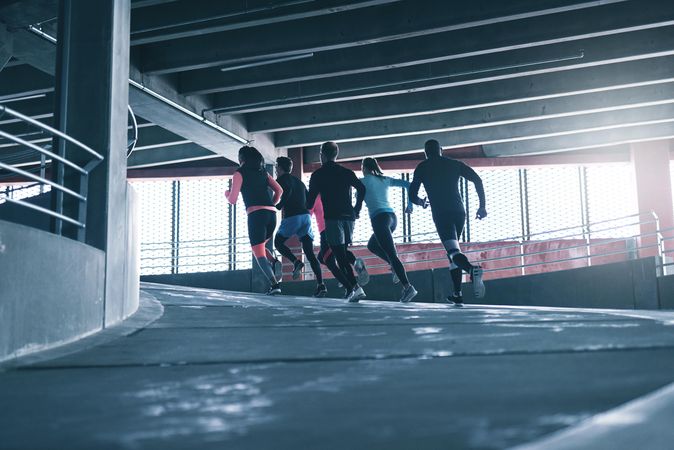 Group of sporty people running up an incline