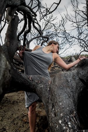 Woman posing on twigs of dry trees