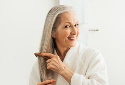 Mature woman combing her hair with a wood comb