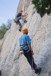 Climbers in safety harness climbing mountain