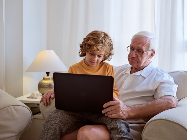 Boy with grandfather surfing laptop