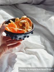 Hand holding bowl of oranges and pancakes in morning sun 56KGx4