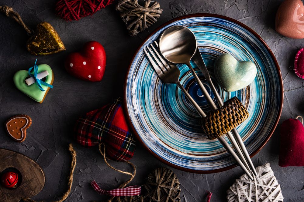 St. Valentine day table setting with colorful blue plates and heart ornaments