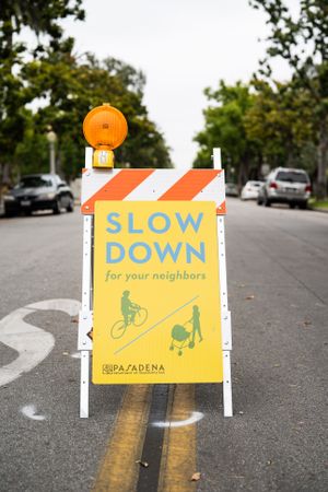 “Slow down” sign in the middle of city street