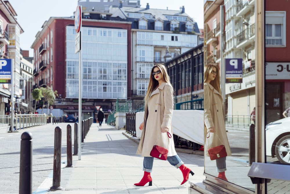 Young happy trendy woman walking in city