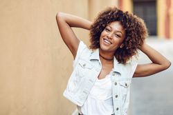 Happy female outside with hands in her hair