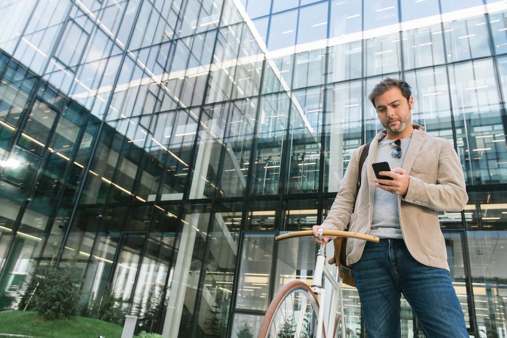 Man phoning while standing against modern building in downtown