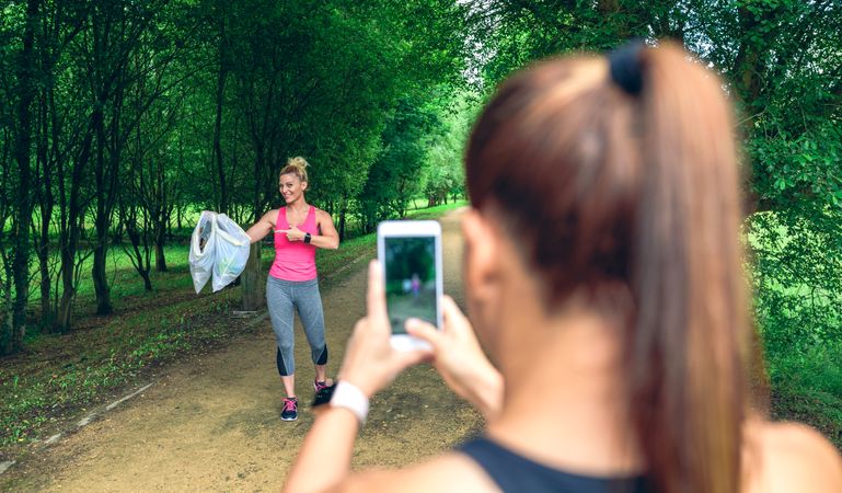 Woman taking picture of a friend after plogging