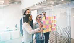 A corporate team brainstorming together in a bright modern office