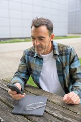 Cheerful man with smartphone and notebook