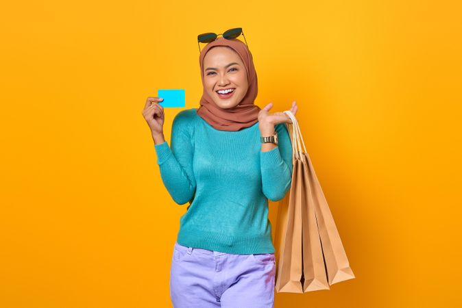 Muslim woman holding shopping bags and credit card