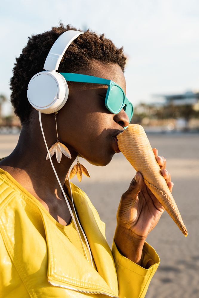 Cool female eating ice cream on beach