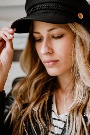 Woman thoughtfully looking away touching cap