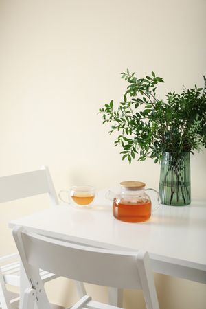 kitchen table with tea and plant in bright room