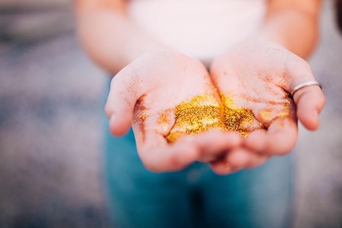 Young woman holding gold glitter