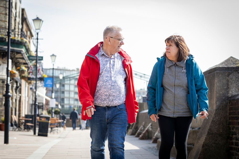 Older man and woman walking together on sidewalk