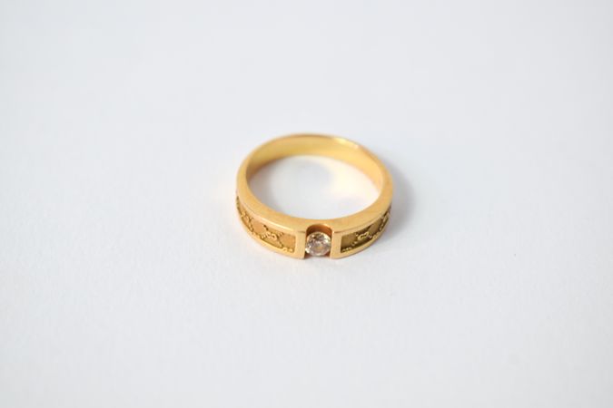 One diamond gold ring on plain table